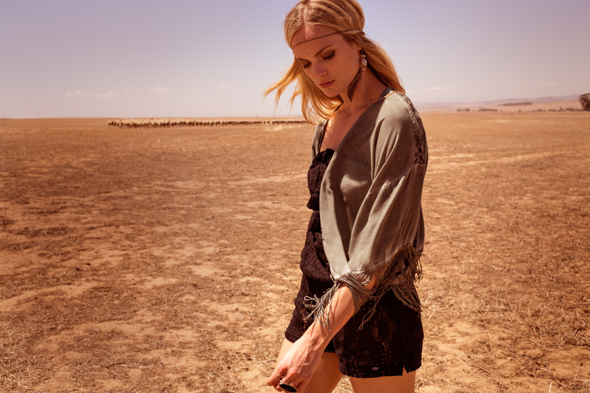 Vrouw met fashion die poseert in een woestijn