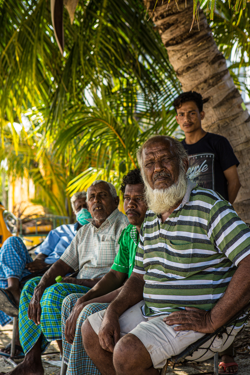 Mensen op strand voor palmbomen in Malediven